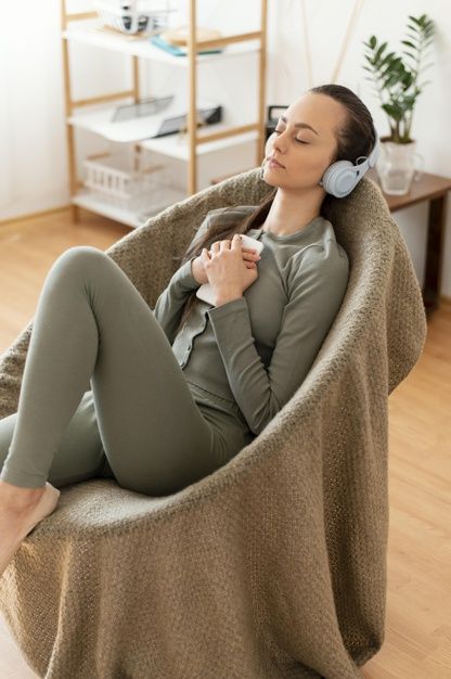 Mujer meditando en casa en silla | Foto Premium